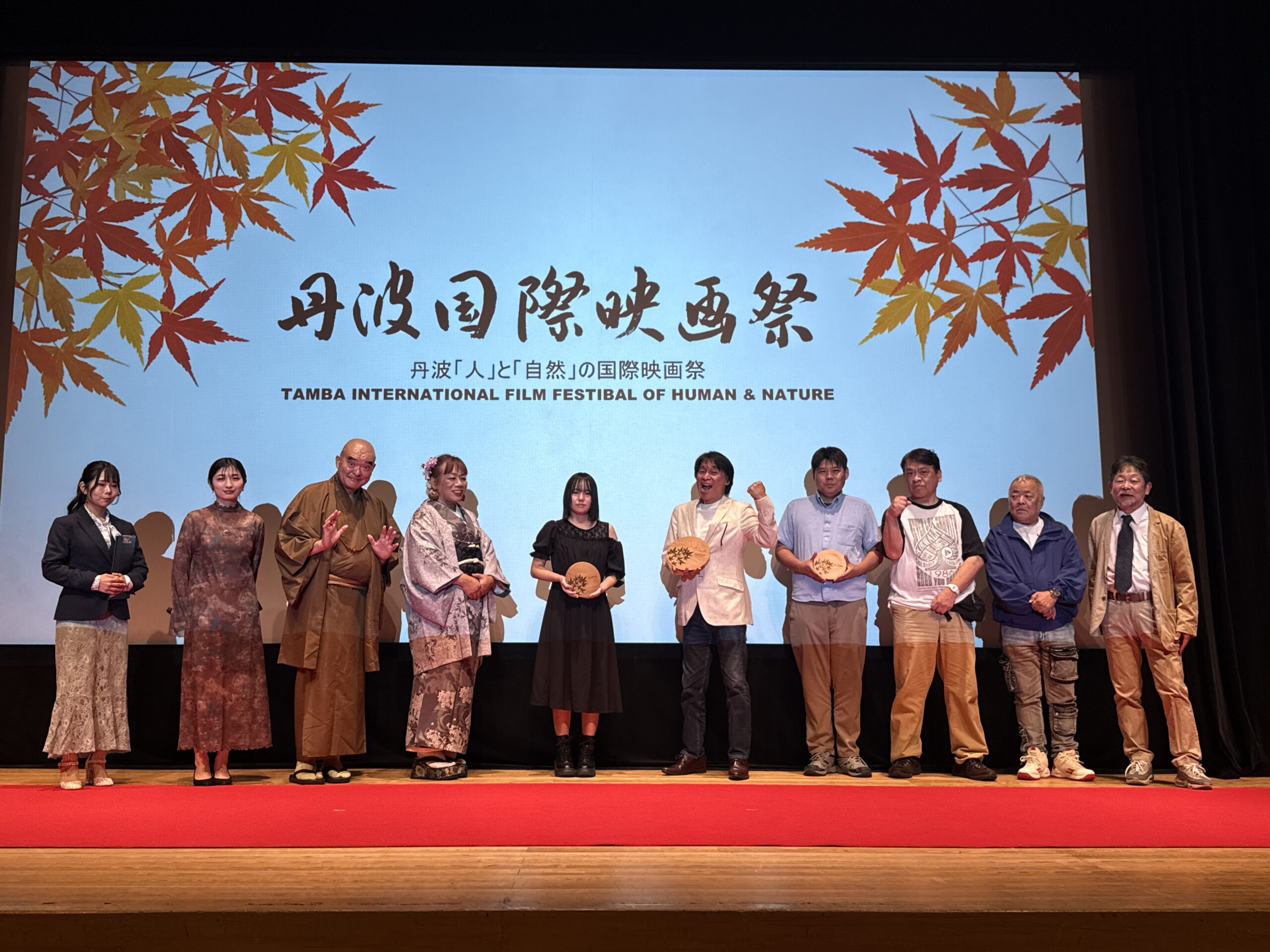 授賞式でポーズをとる主演